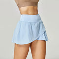 Women's solid colour quick-dry sports shorts in black, blue, red, and white on a mannequin.