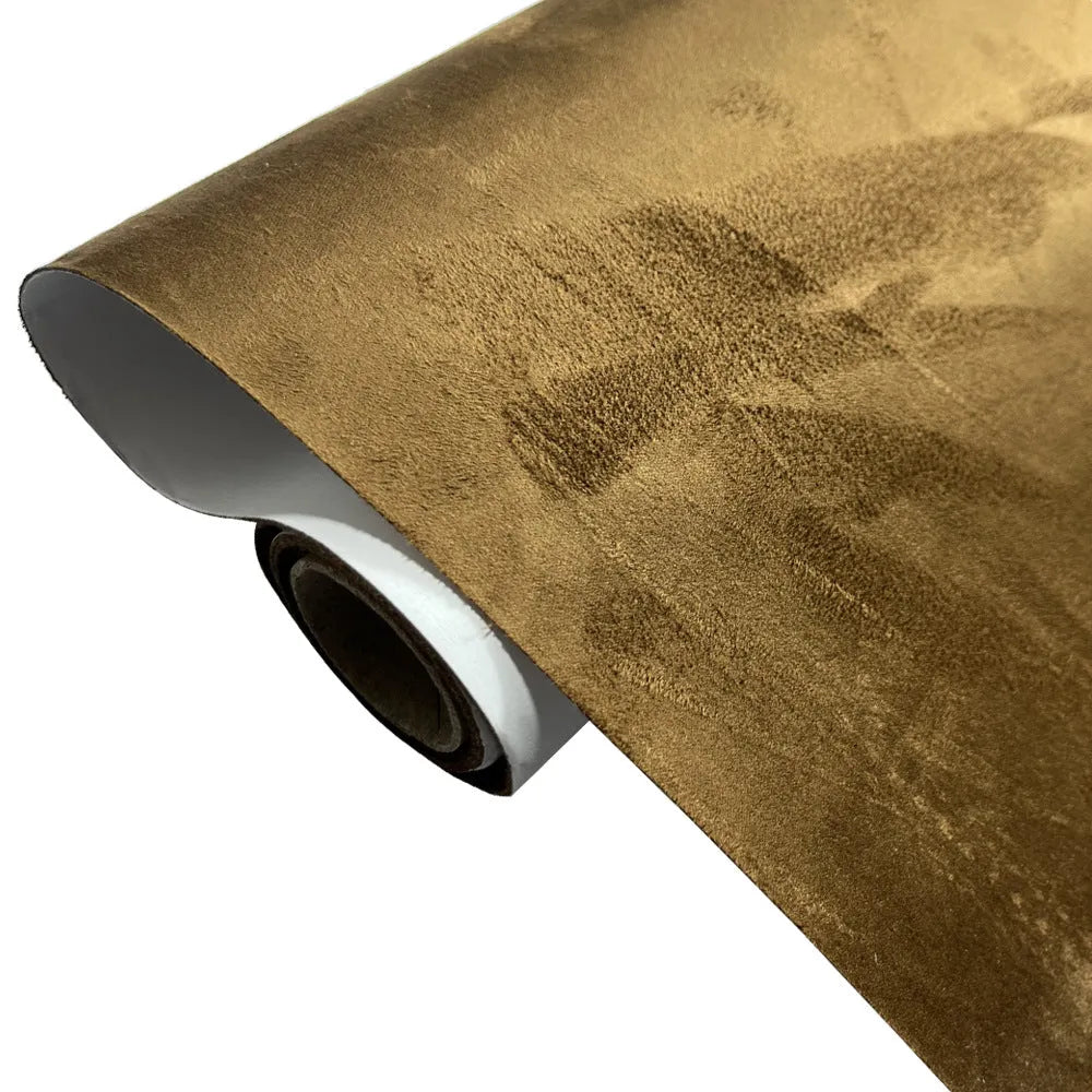Roll of self-adhesive black leather suede fabric with adhesive backing visible, showing texture.