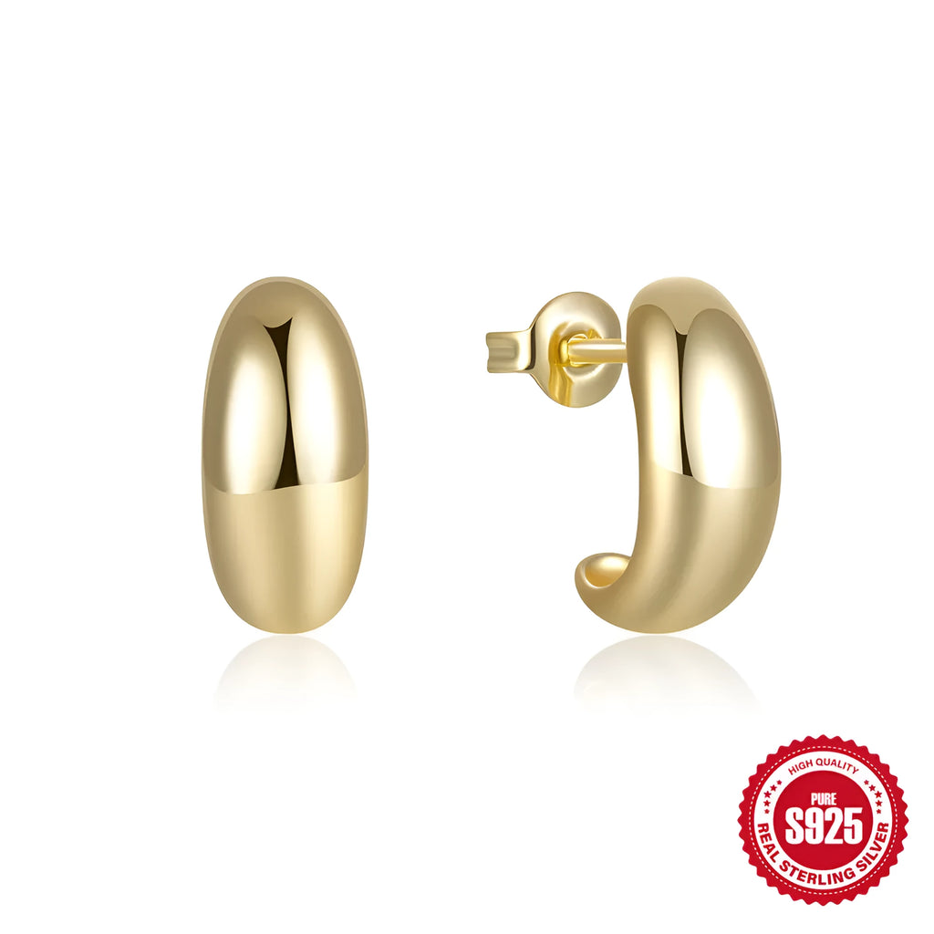 Close-up of a glossy C-shaped sterling silver stud earring in gold electroplated finish on a plain background.
