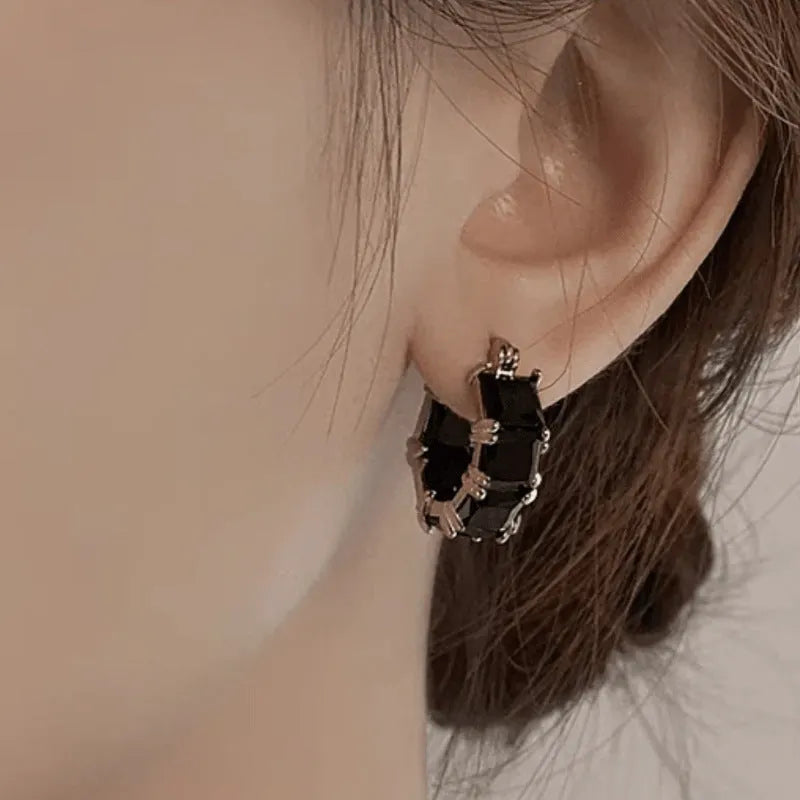 Geometric U-shaped earrings with round crystal zirconium stones in gold setting
