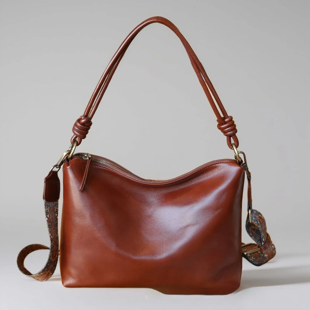 Genuine leather creative large capacity hand and shoulder commuter bag in caramel colour with pillow shape and patchwork details