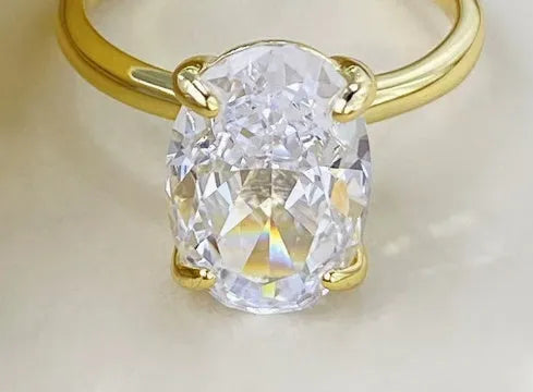 Oval women's ring with four-claw setting and oval gemstone in gold or silver finish
