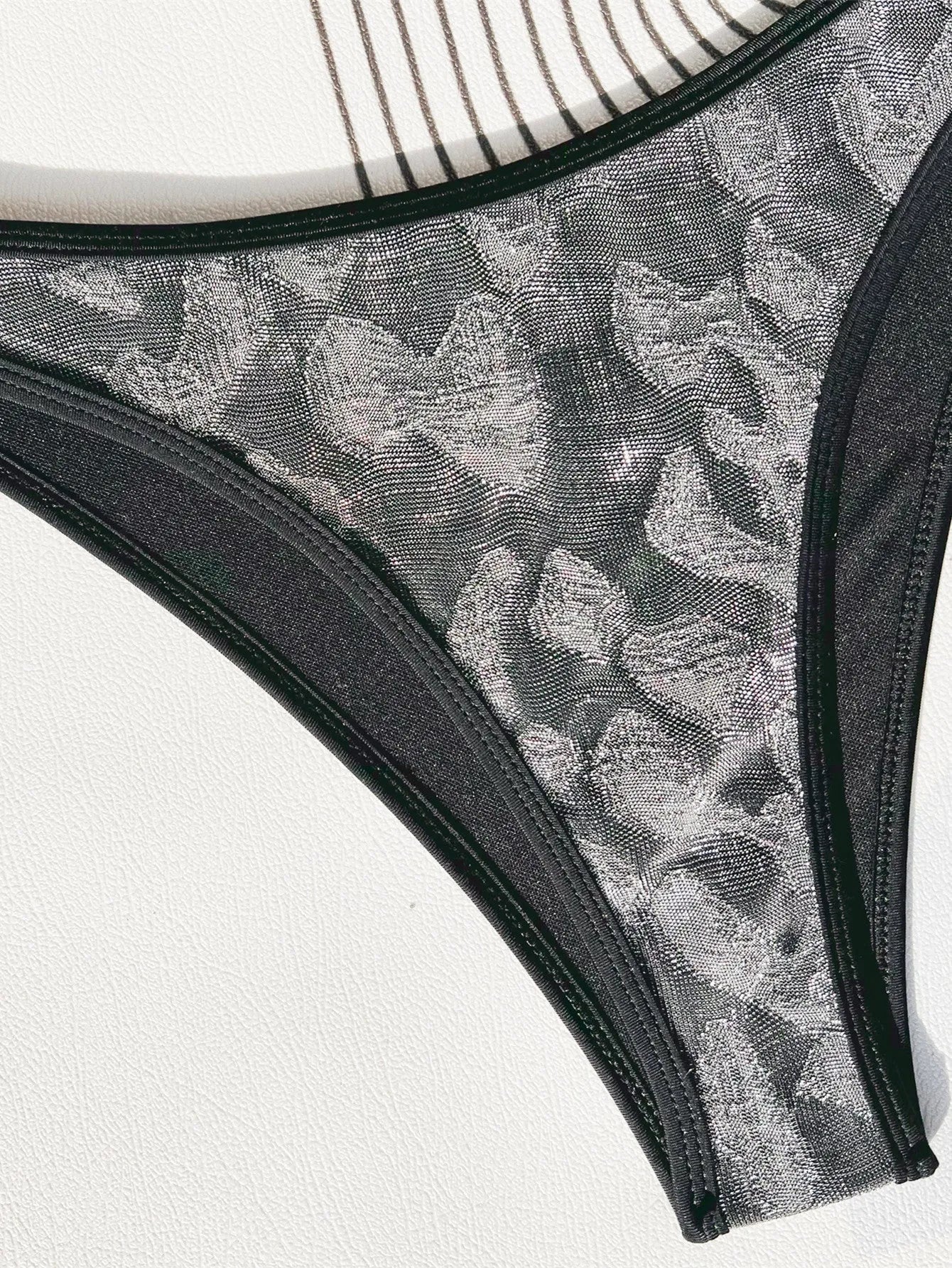 Black ladies bikini swimsuit with stitrap design on a mannequin.