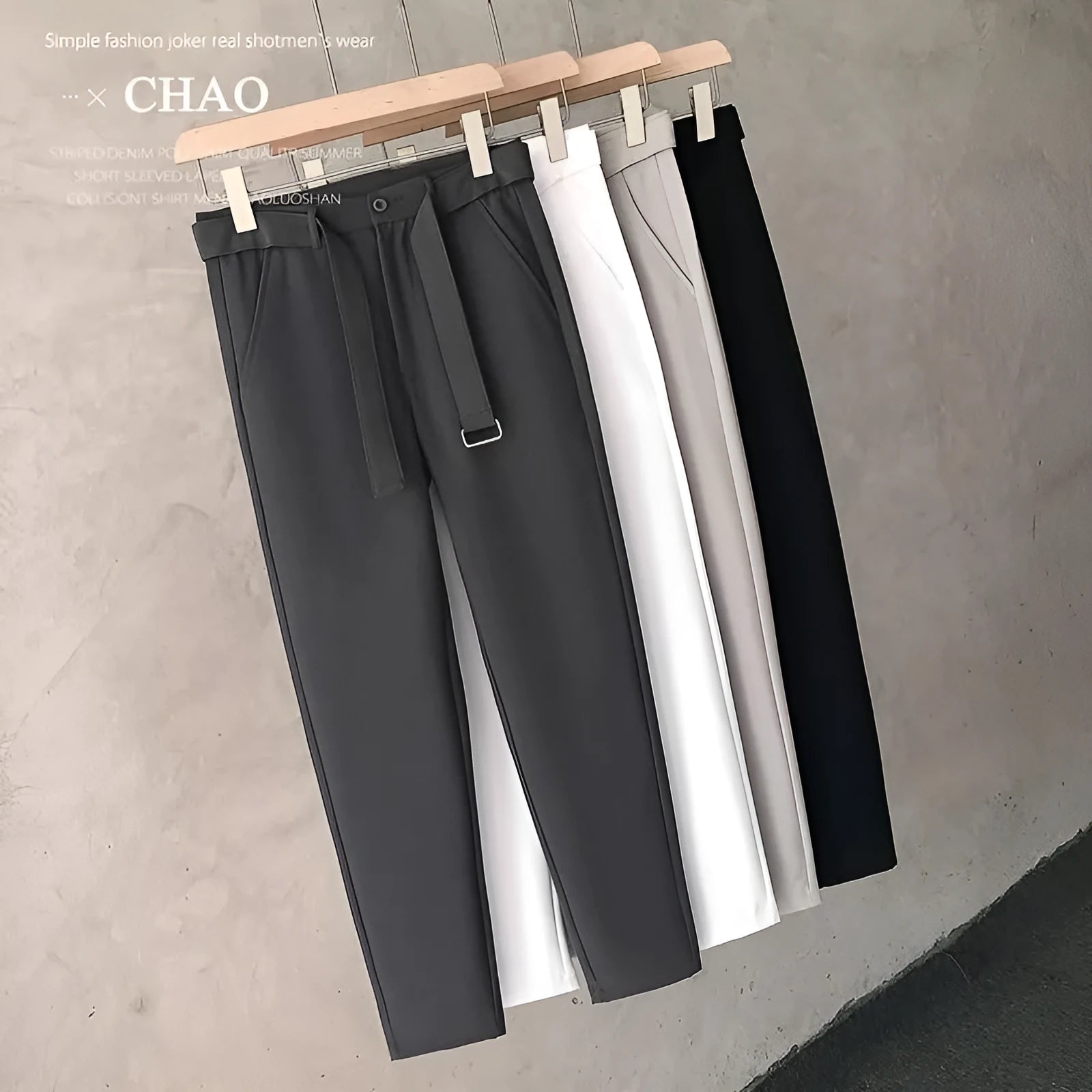 Boys slim straight-leg wool trousers in tapered cut, shown in black, on a hanger.