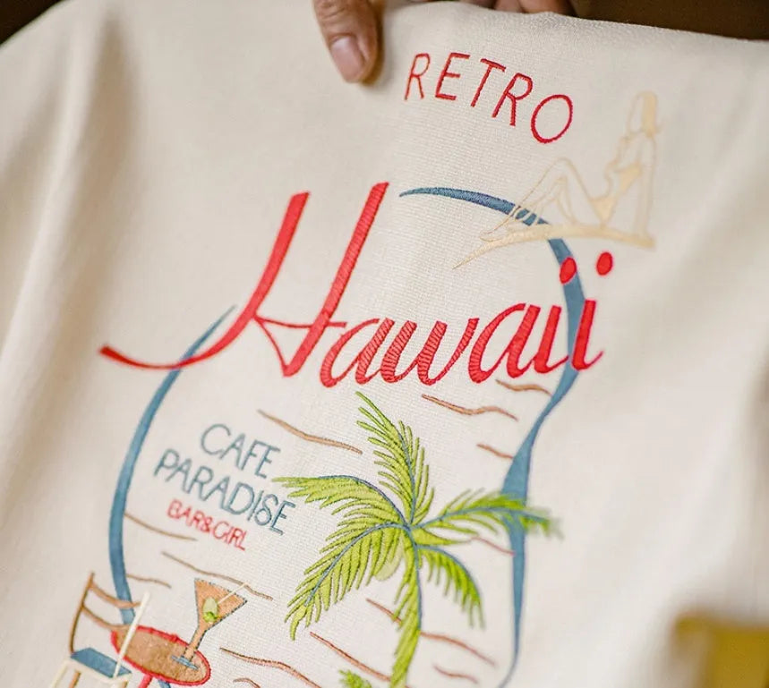 Light apricot men's shirt with bamboo pattern and Cuban collar laid flat.