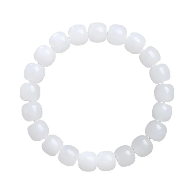 White Hetian jade barrel bead bracelet on a wrist, showing the traditional bead design.