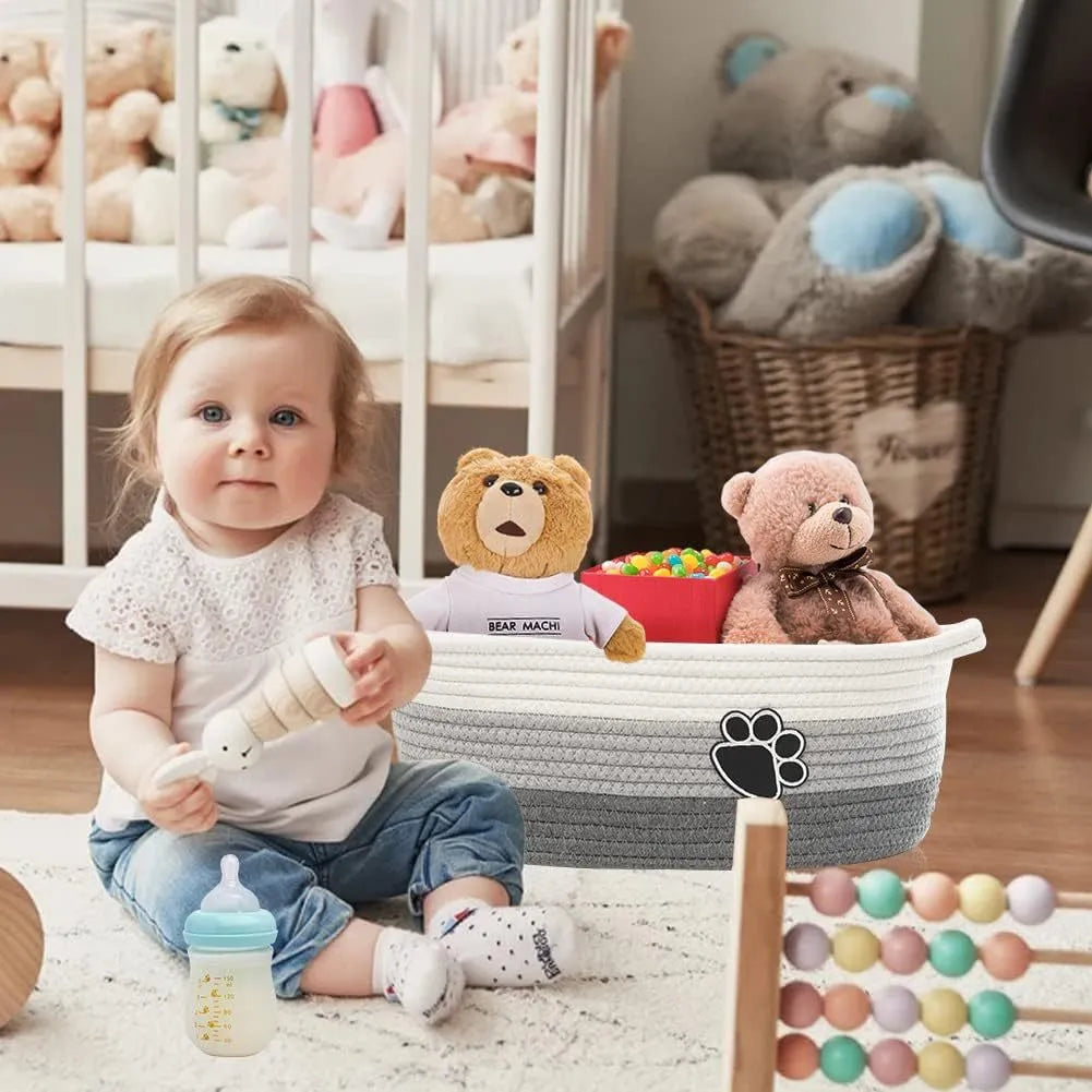 Light beige handmade woven cotton rope storage basket with wood accents and a handle.