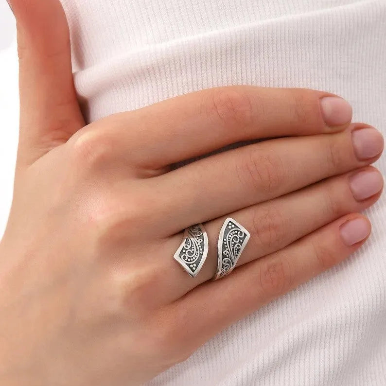 Silver-coloured adjustable opening women's ring with a retro minimalist style on a grey background.