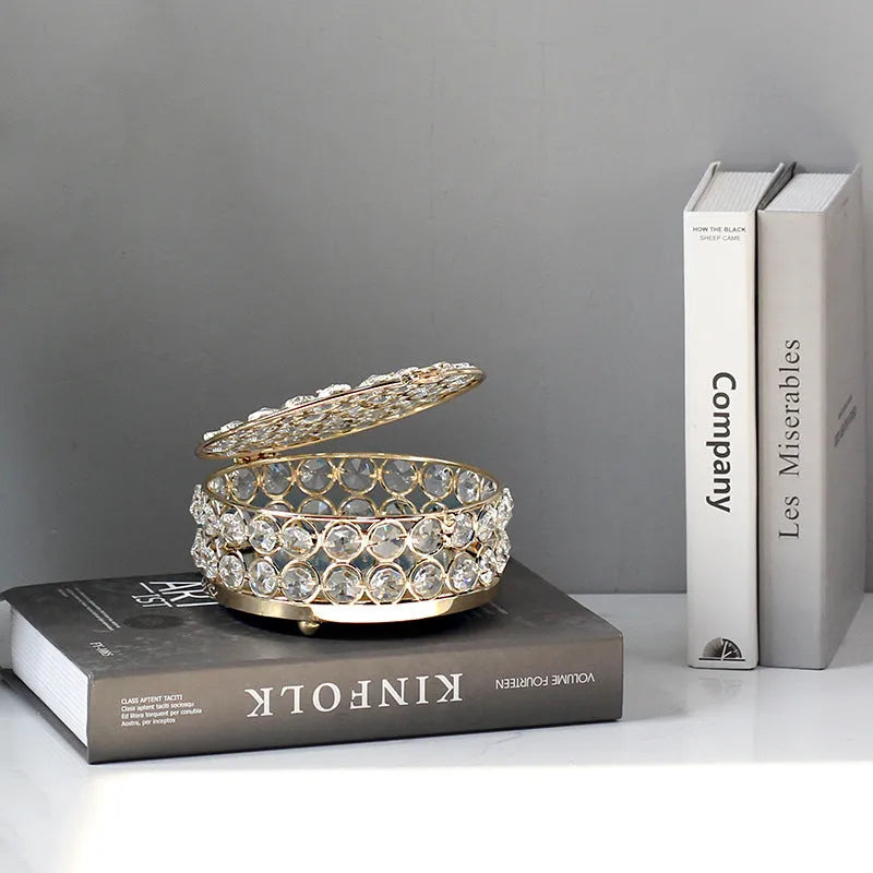 French gold metal jewellery box with a transparent crystal glass lid on a table.