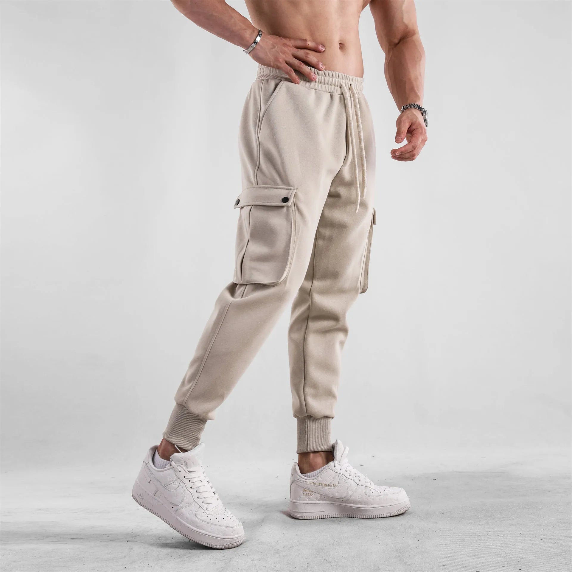Men's loose cotton trousers with ankle ties and multiple pockets in solid apricot colour