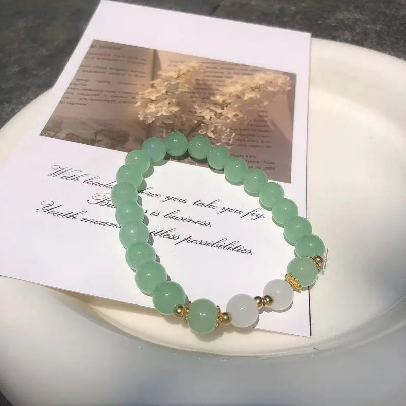 Chinese style handmade glass bead bracelet with bamboo joint elements on a white background.