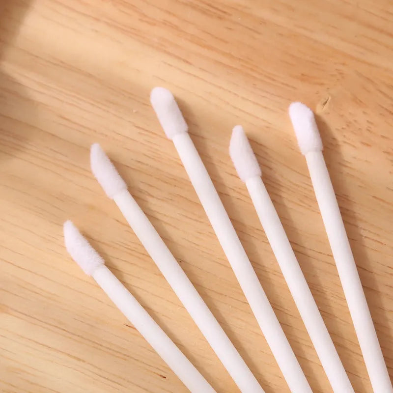 Pack of disposable lip brushes with flocked heads and coloured handles, shown in quantities from 200 to 500 pieces.