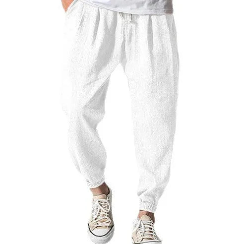 Men's loose-fitting cotton trousers with elasticated ankle bands in light green colour showing casual summer style