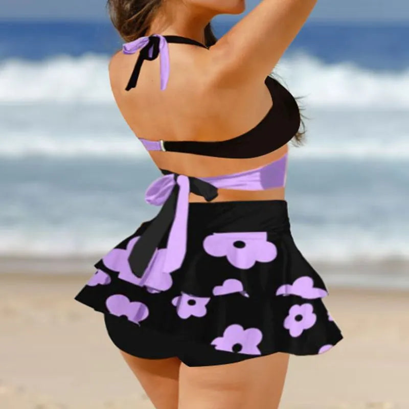 Women's purple bikini swimsuit with matching skirt featuring high waist briefs and lace-up design
