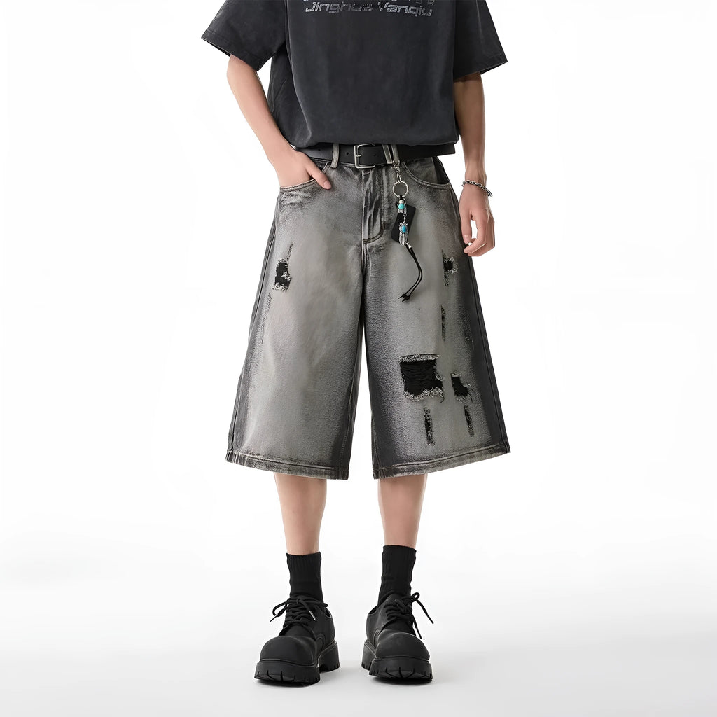 Grey women's denim shorts with distressed hole details and a loose, cropped fit