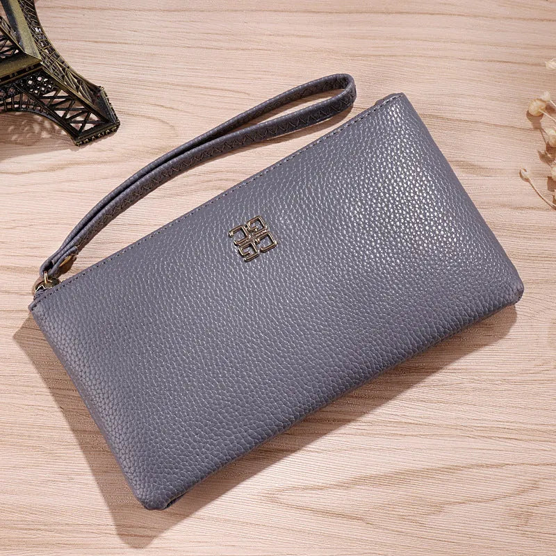 Long wine red PU leather zip wallet handbag worn crossbody, showing card slots and sewing line detail.