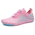 White and pink lace-up sports shoes with rubber sole on a plain background