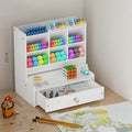 Square plastic pen organiser storage box with multiple oblique insertion grid compartments on a desk.