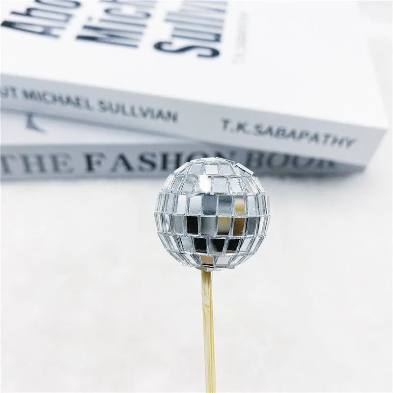 Glass disco ball cake decoration with wooden stick on a birthday cake