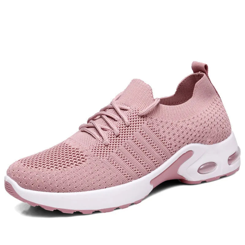Women's grey lace-up sneakers with mesh upper and soft PVC sole on a light background.