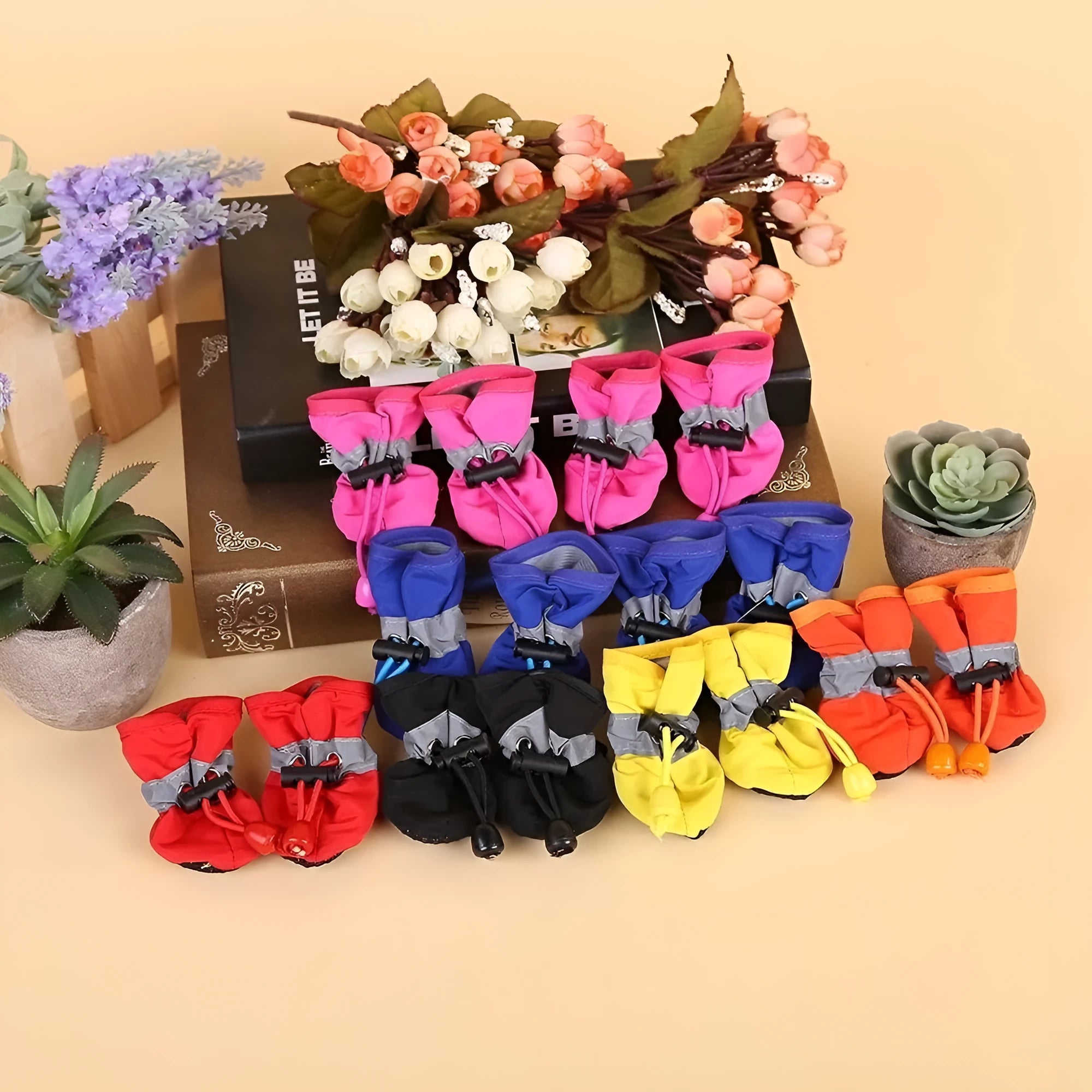 Set of four cloth dog shoes with soft soles in assorted colours on a neutral background