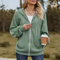 Green women's hooded sweater coat with front zipper, shown on a model in a casual setting.