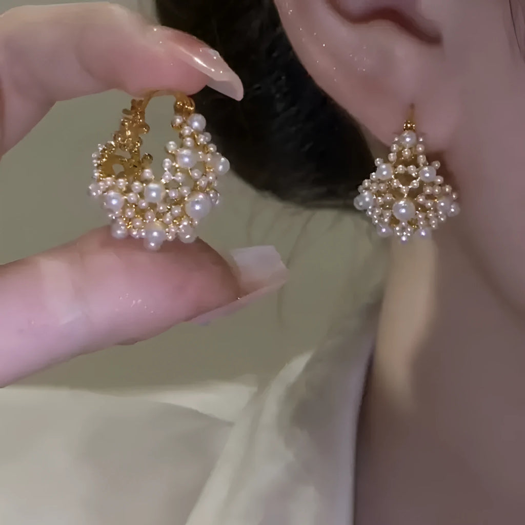 Gold women's copper earrings in a flower basket shape decorated with small rice-shaped beads.