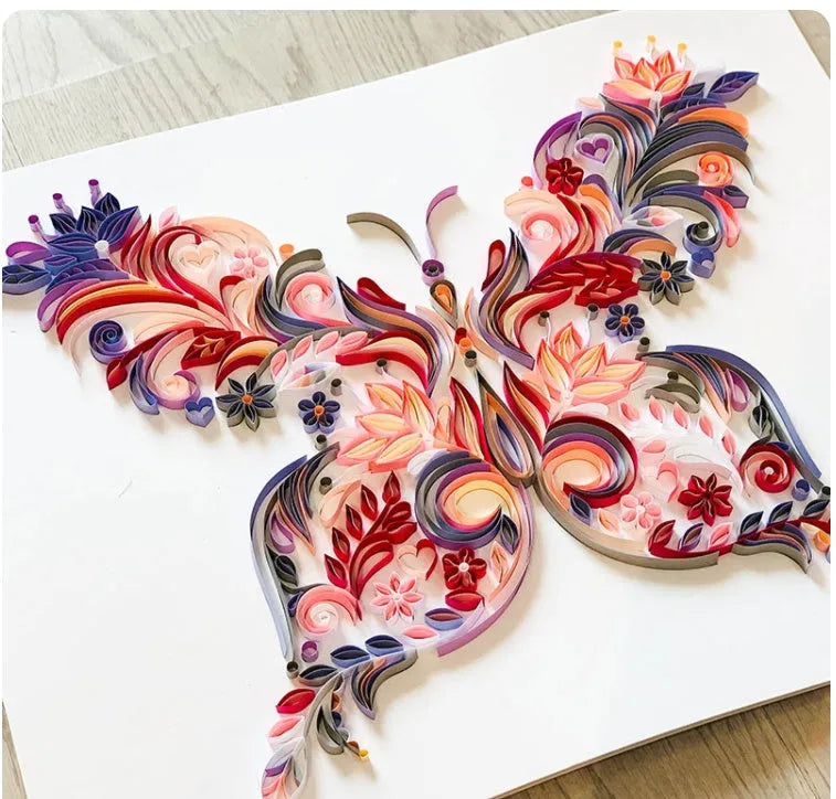 20 inch handmade butterfly quilling paper ornament with craft tools on blue background