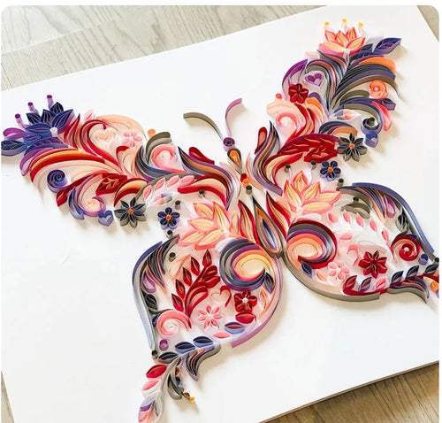 20 inch handmade butterfly quilling paper ornament with craft tools on blue background