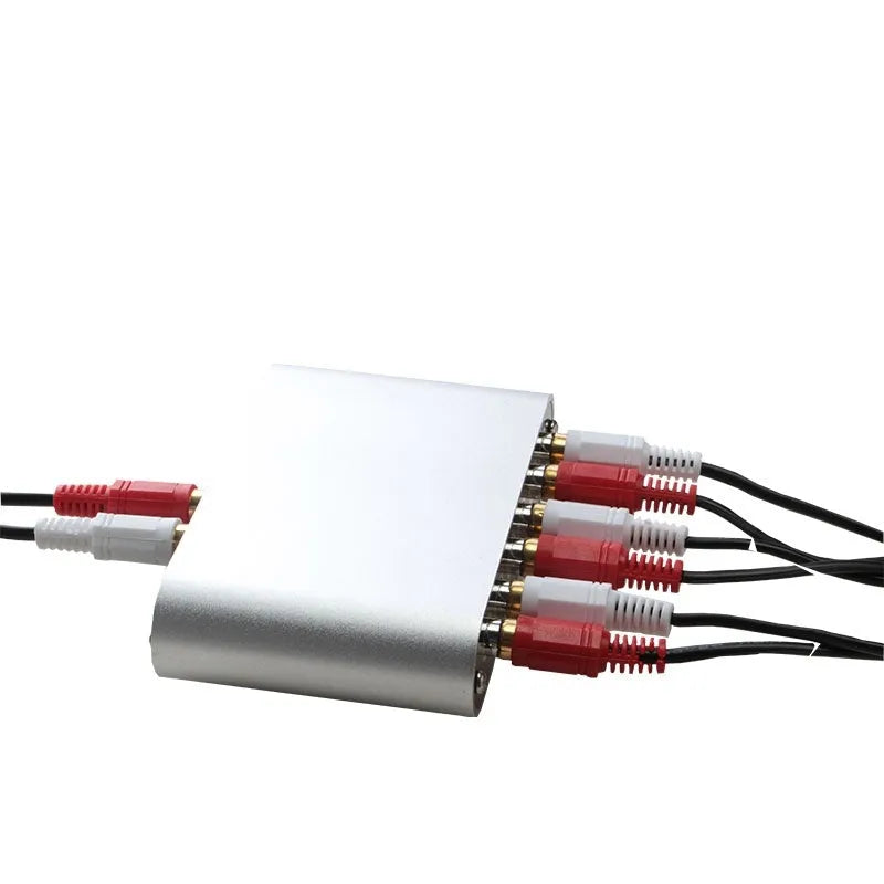 Silver aluminium audio source selector switch with infrared remote control on a shelf.