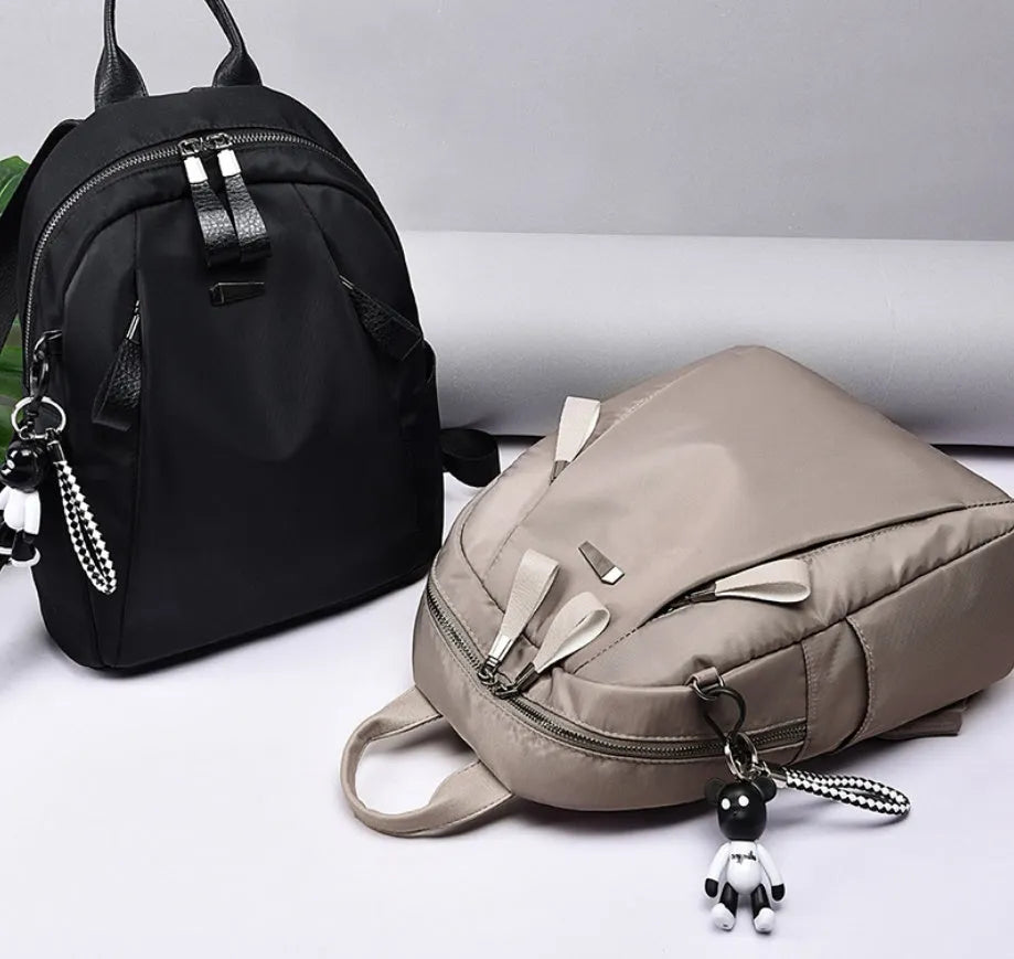 Medium-sized Oxford cloth rucksack in wine red, showing dual straps and external pocket.