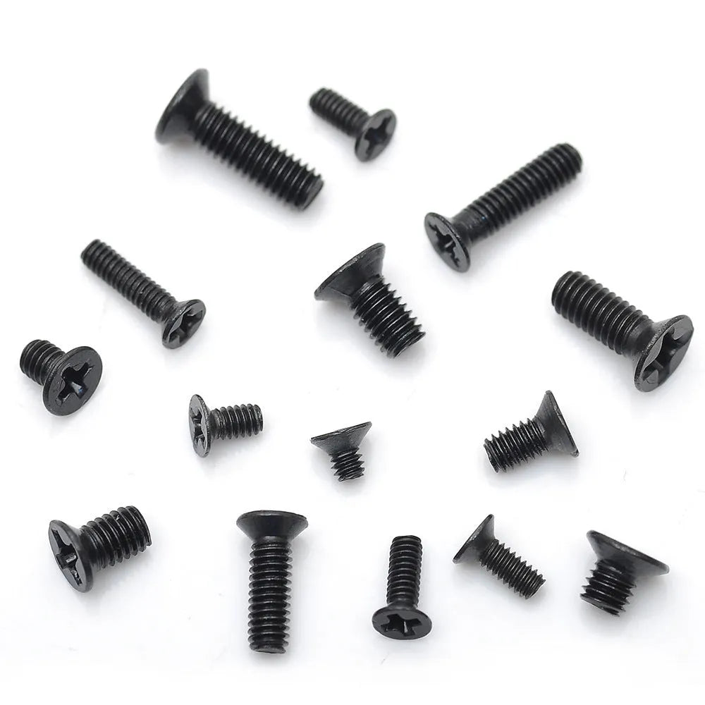 Black countersunk head machine screws for laptop repair, shown in a pile next to a box.