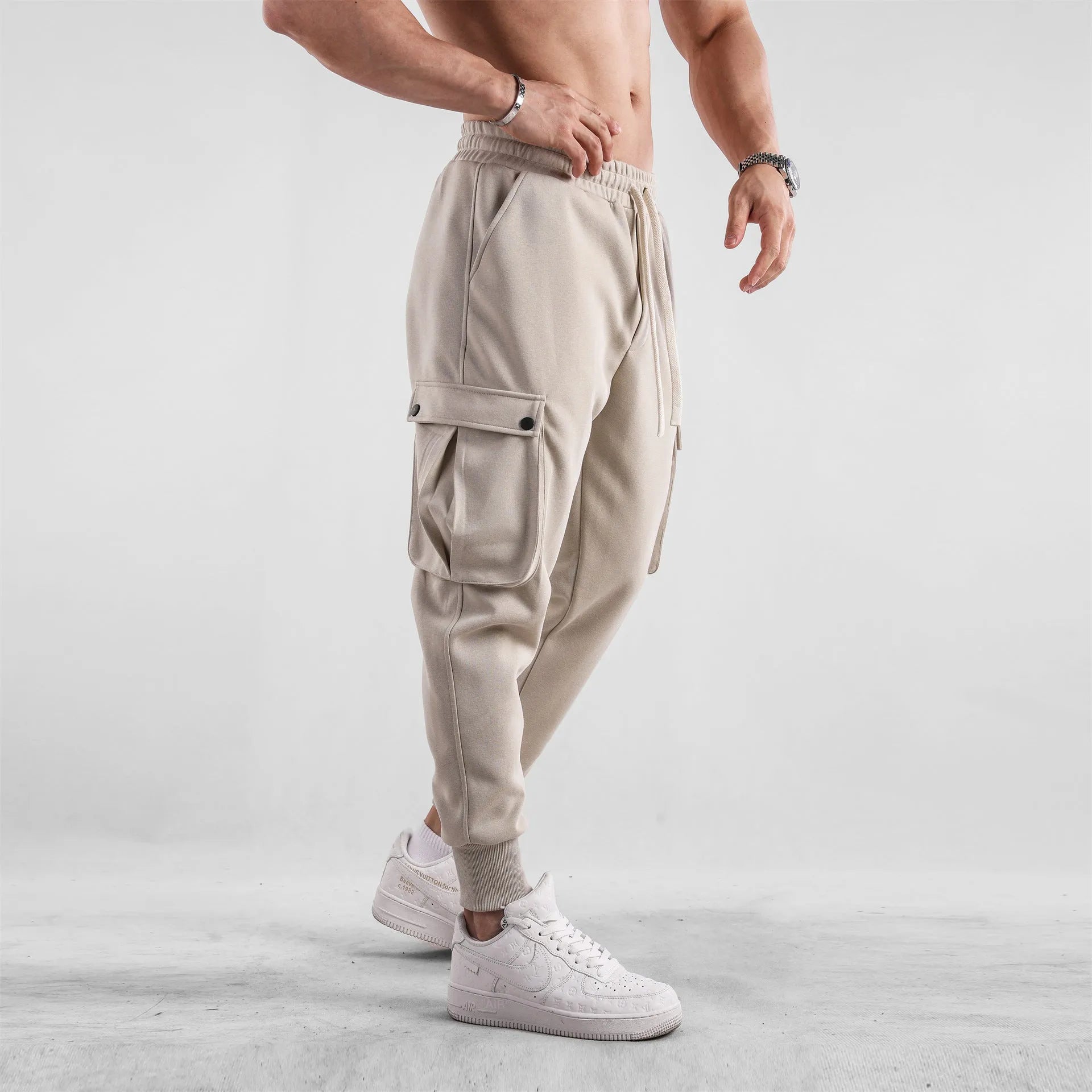 Men's loose cotton trousers with ankle ties and multiple pockets in solid apricot colour