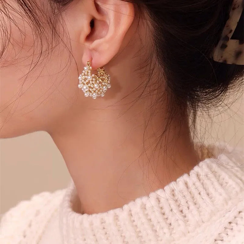 Gold women's copper earrings in a flower basket shape decorated with small rice-shaped beads.