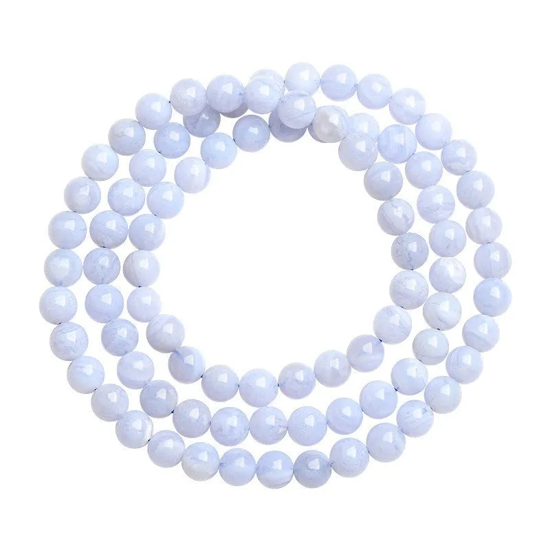 Close-up of a blue agate bracelet with multi-circle patterns, striped beads, and a Ruyi element on a neutral background.