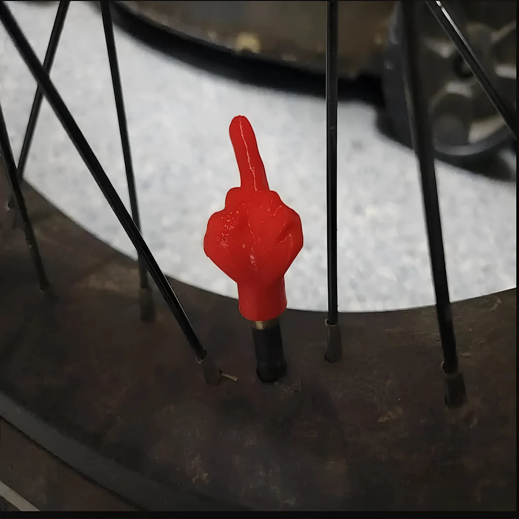 Four latex car tyre valve dust caps, two black and two skin colour, arranged together.
