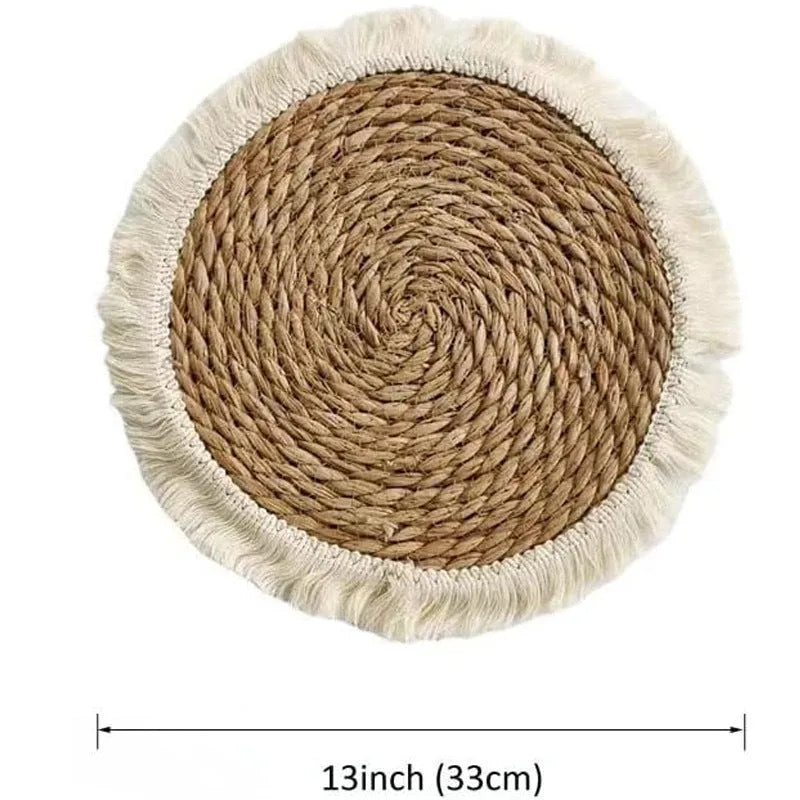 A round natural papyrus straw placemat with decorative tassels, shown in a solid colour.