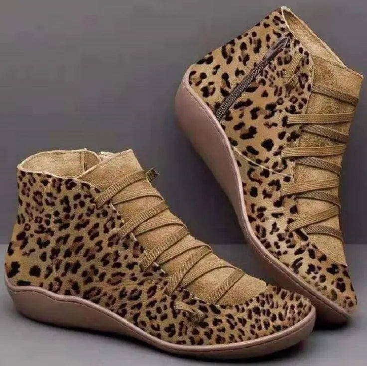 Women's black casual ankle boot with a flat wedge heel and round toe on a plain background.