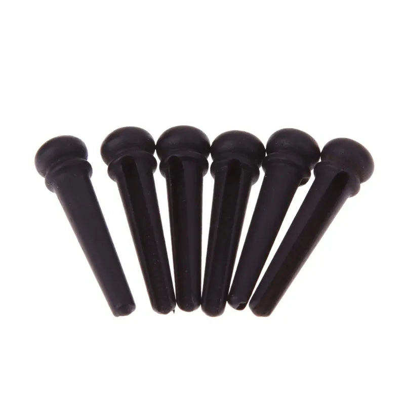Six solid ebony guitar string nails with matte black finish for folk acoustic guitars