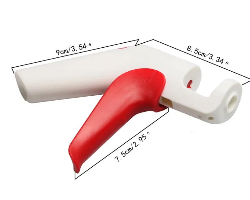 Cherry stoner tool with stainless steel pitting head and white plastic handle on a wooden surface.