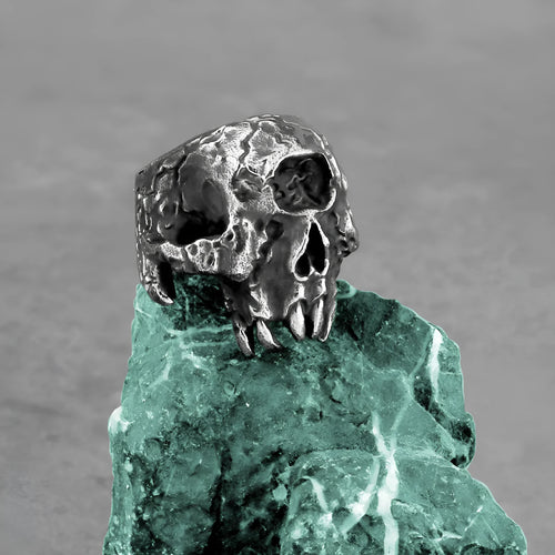 Silver-toned alloy skull ring with a detailed one-eyed design on a black background.