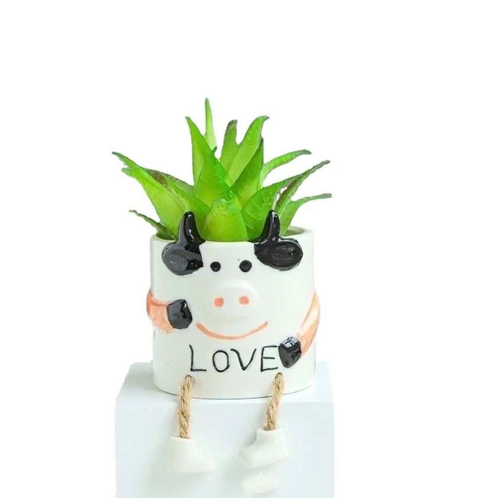 Ceramic cartoon-style hanging foot flowerpot for succulent plants on a desktop.