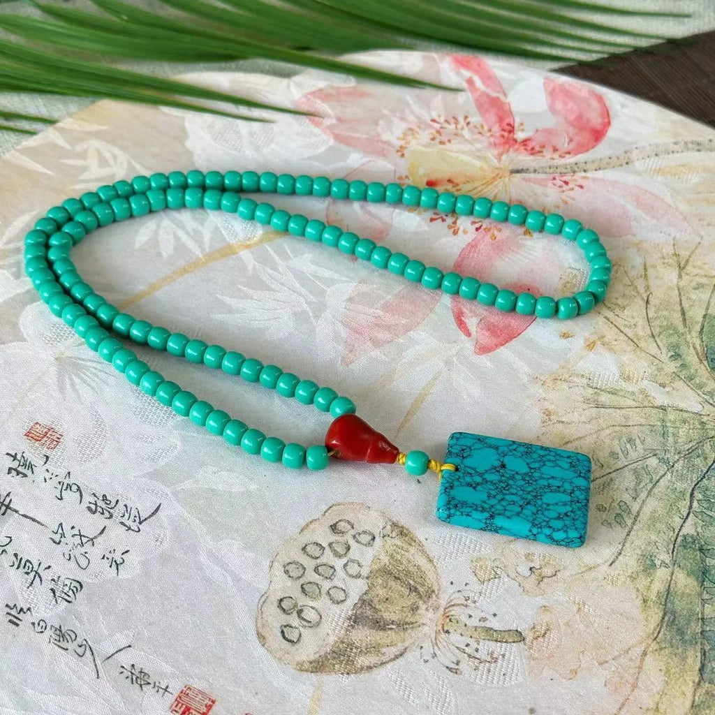 Turquoise necklace with stone pendant on ball bead chain, showing mesh flower design