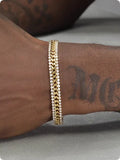Gold tennis bracelet with gemstone inlay on titanium steel band.