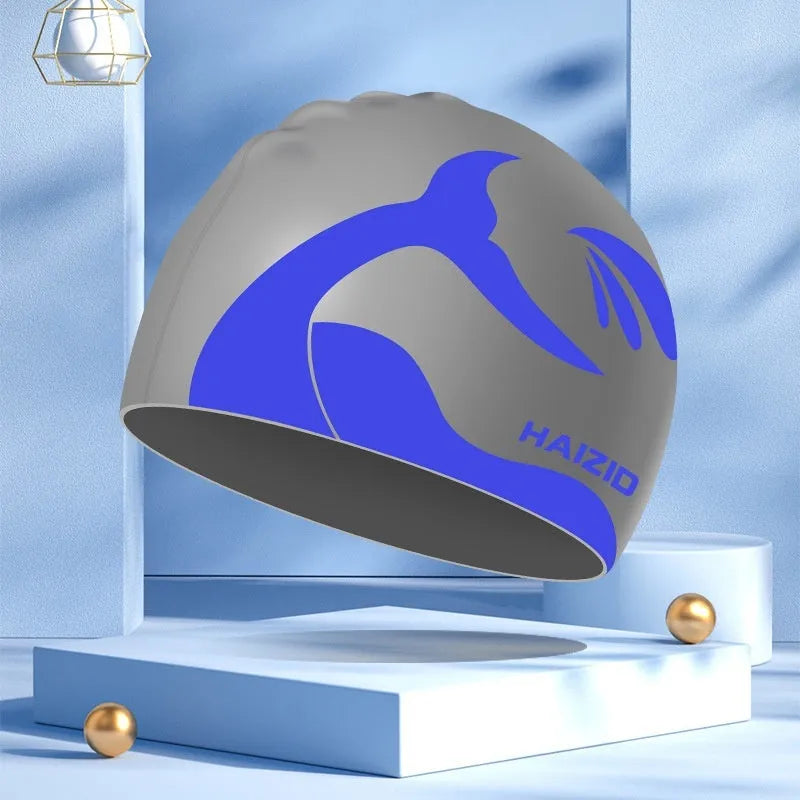 Silicone swimming cap with whale tail pattern and integrated ear protectors in grey.