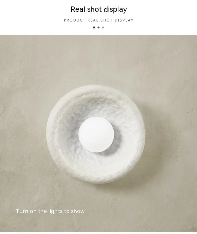 Japanese-style modern simple wall lamp with a round resin shade in warm white light.