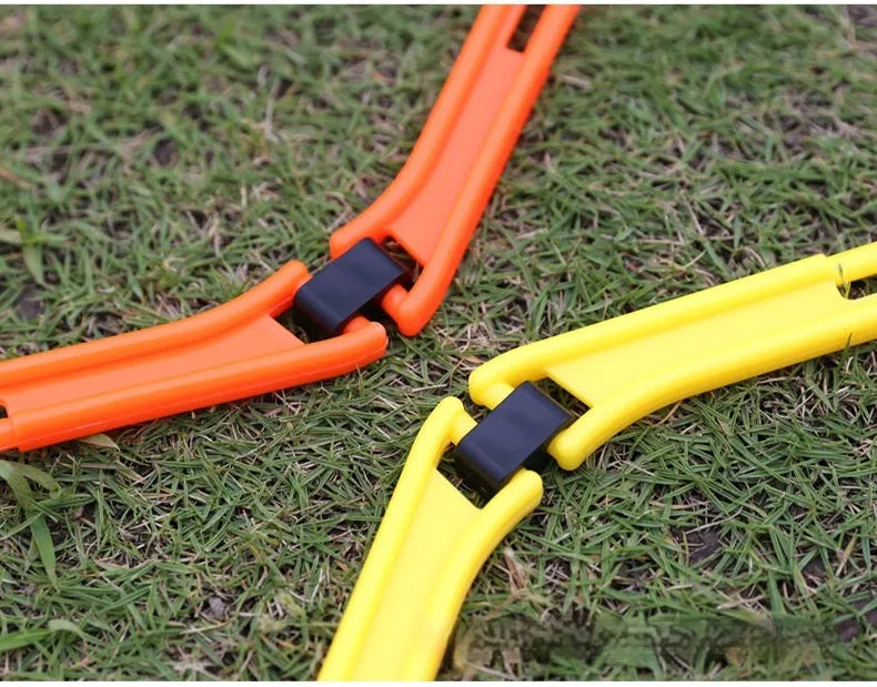 Six foldable hexagon football agility training rings in yellow, green, and orange colours laid out on grass.