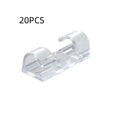 Transparent plastic self-adhesive cable management clips in four sizes on a white background.
