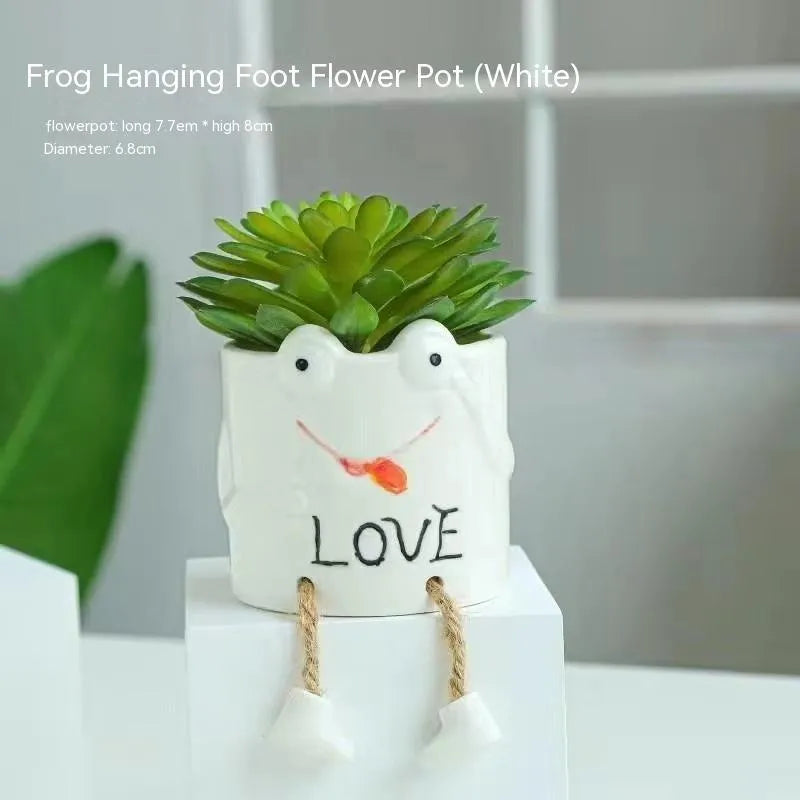 Ceramic cartoon-style hanging foot flowerpot for succulent plants on a desktop.