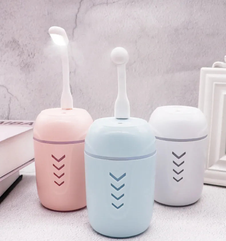 Blue X3 portable columnar humidifier with USB cable on a car dashboard.